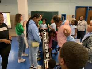 Photograph of Northeast Maglev team members and children laughing and racing maglev models